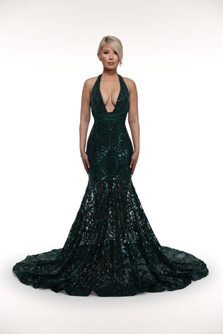 Woman wearing a dark green sequin gown on a white background