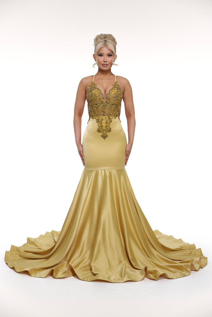 Gold evening gown with intricate detailing on a white background