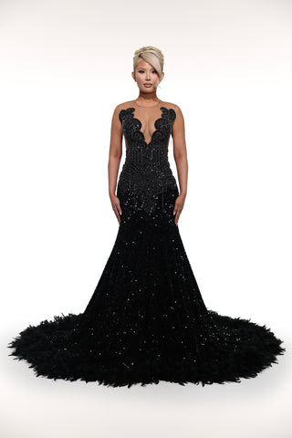 Black evening gown with intricate detailing on a white background