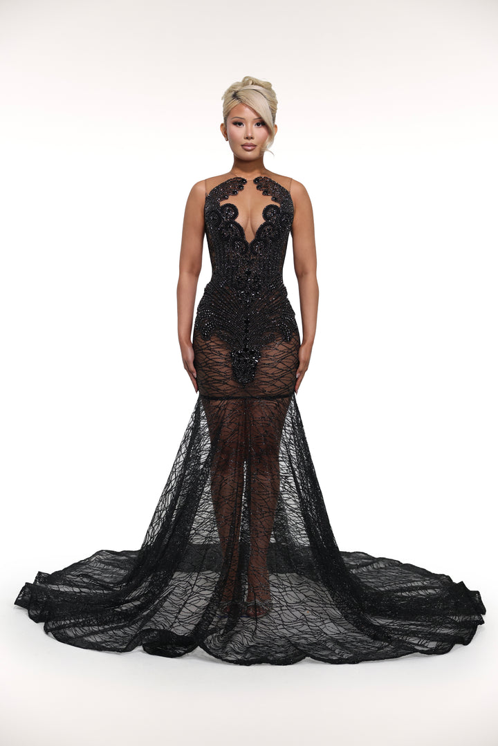Black evening gown with intricate detailing on a white background